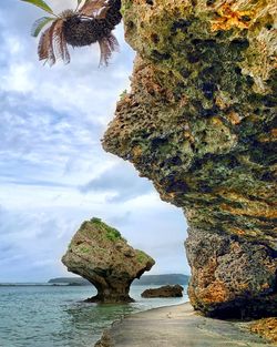 Rock formation amidst sea against sky