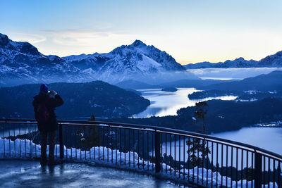 Man standing on snowcapped mountain against sky