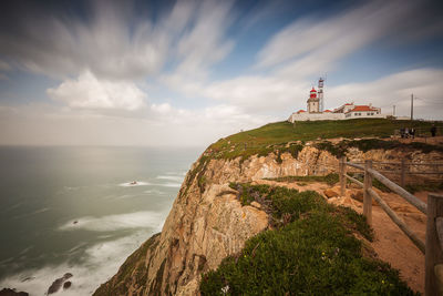 Scenic view of mountain by sea against sky