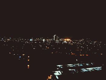 Illuminated cityscape against sky at night