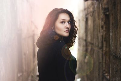 Portrait of woman looking over shoulder outdoors