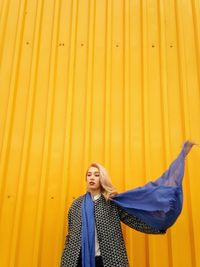 Young woman against yellow wall