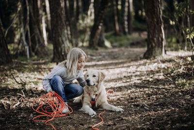 Woman with dog on field in forest