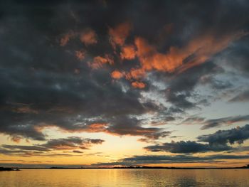 Scenic view of sea against dramatic sky during sunset