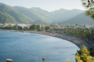 High angle view of townscape by sea against mountains