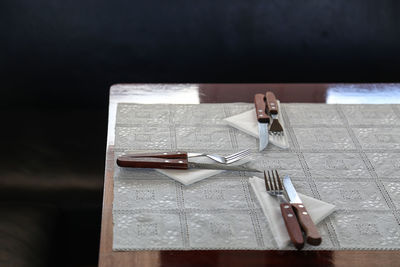 High angle view of cutlery and napkins on dining table