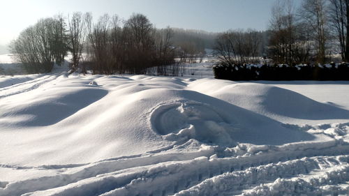 Snow covered field against sky