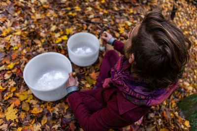 High angle view of girl with autumn leaves