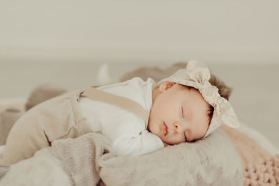 Cute baby girl sleeping on bed at home