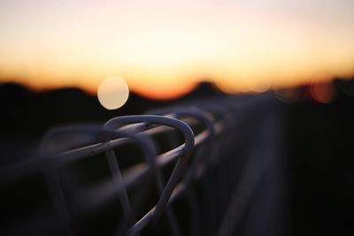 Close-up of silhouette metal against sky during sunset