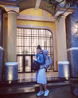 Full length of woman standing against building