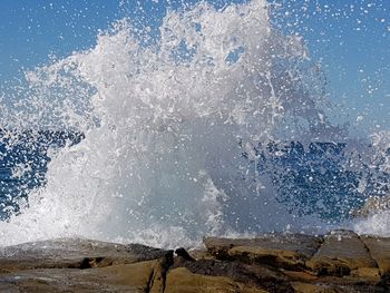 Scenic view of sea waves splashing on rocks