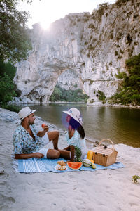 People sitting on ice cream over water