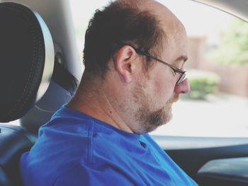 Side view of mature man sitting in car