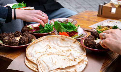 Cropped hand of person preparing food on table