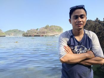 Portrait of young man standing against clear blue sky