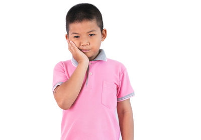 Portrait of boy standing against white background