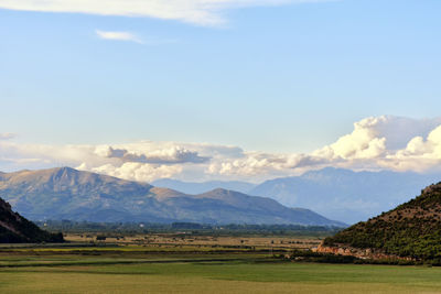 Scenic view of field and mountains against sky