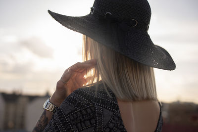 Close-up portrait of woman wearing hat against sky