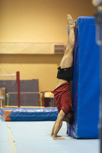 Side view of young man exercising at gym