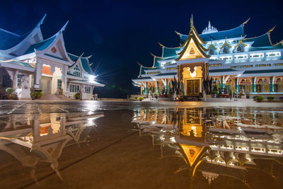 Illuminated temples reflecting on water at night
