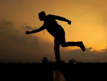 Silhouette man standing against sky during sunset