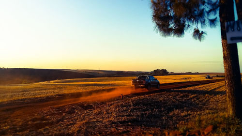 Car on road against sky at sunset