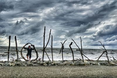 Man standing at beach against sky
