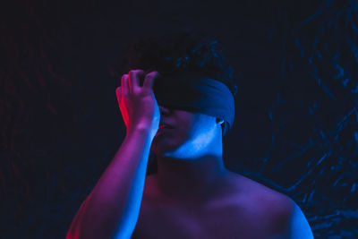 Portrait of shirtless man in darkroom