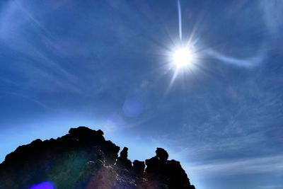 Sun shining through clouds over mountains