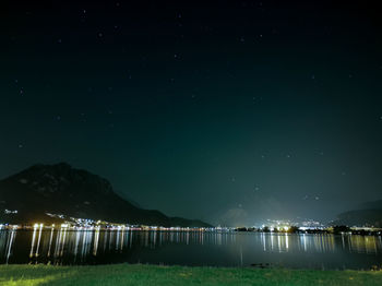 Scenic view of lake against sky at night