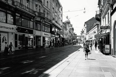 People walking on road along buildings