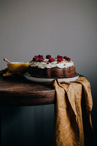 Close-up of cake on table against wall at home