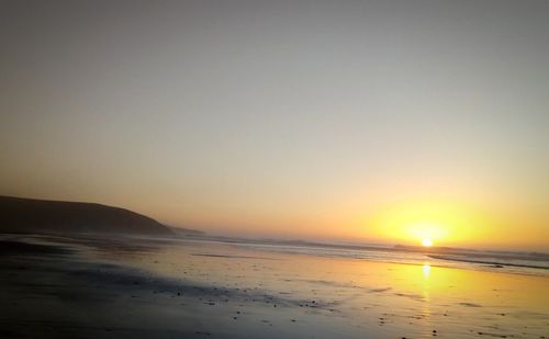 Scenic view of sea against clear sky during sunset