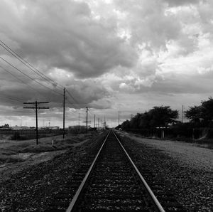 Railroad track against cloudy sky