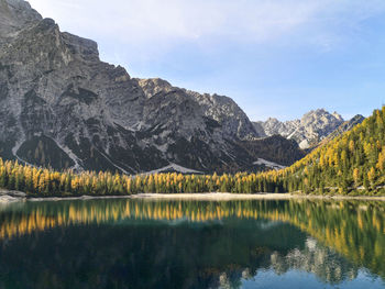 Natural landscape of braies lake with green trees, lake with reflection and mountain with snow