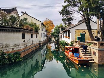 Canal amidst buildings against sky