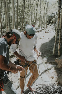 High angle view of friends preparing for mountain climbing