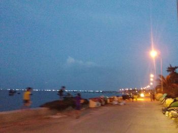 People at beach against sky