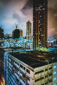 Modern buildings in city against sky at night