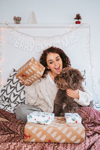 Smiling woman with her dog and christmas gifts