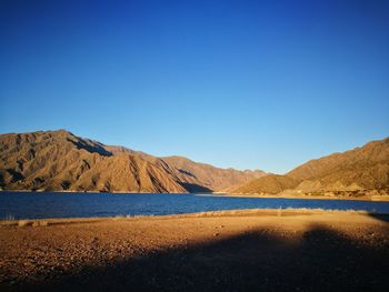 Scenic view of landscape and mountains against clear blue sky