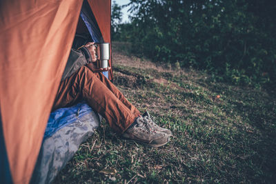 Low section of man relaxing on field