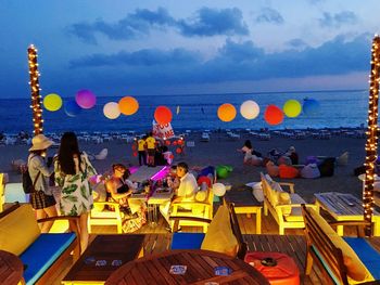 People at beach against sky