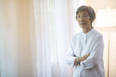 Portrait of senior woman standing at home
