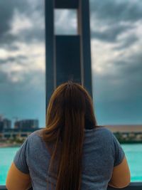 Rear view of woman standing against sky