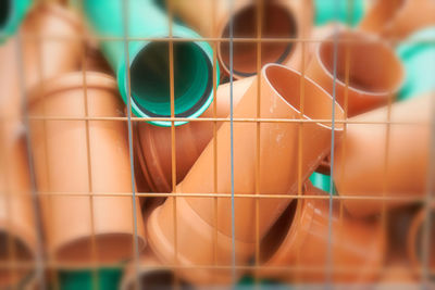 Full frame shot of plastic pipes by metal grate