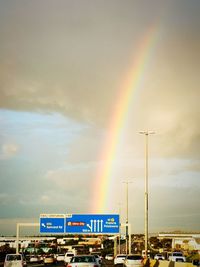 Rainbow over road against sky