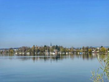 Scenic view of lake against clear blue sky