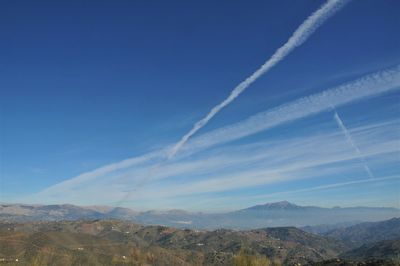 Scenic view of vapor trail in blue sky